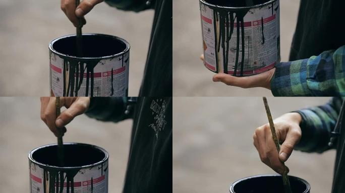 画家在街上的罐子里搅拌油漆
