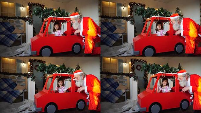 有趣的圣诞老人在红色汽车上与小王子挥手玩耍
