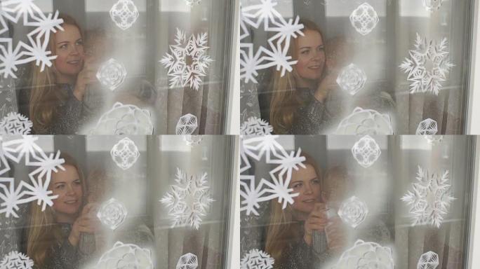 母子俩用假雪装饰窗户。