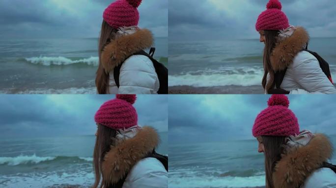 看着大海的年轻女子。冬天
