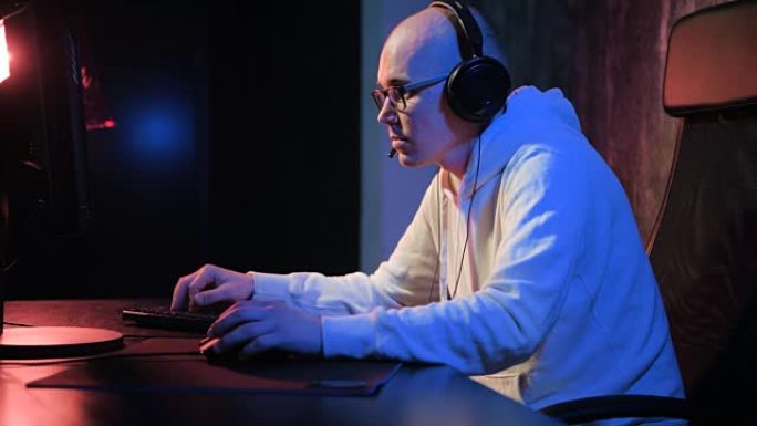 专业玩家在PC计算机上玩激烈的视频游戏。年轻人玩在线竞技游戏并与朋友交谈