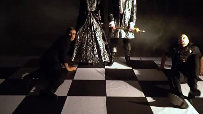 穿黑色衣服的伤员爬回棋盘上。黑暗的国王和王后失望地低着头。现场象棋比赛。