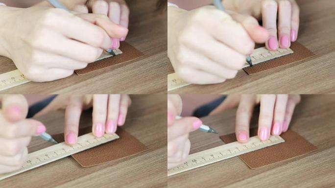 女裁缝用铅笔和尺子测量皮革织物上的片段，女人的手特写。