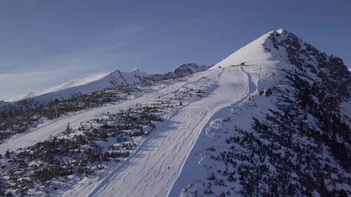 斯洛伐克高塔特拉山脉Strbske Pleso度假村滑雪场上滑雪者的鸟瞰图。原始的未触摸日志格式。