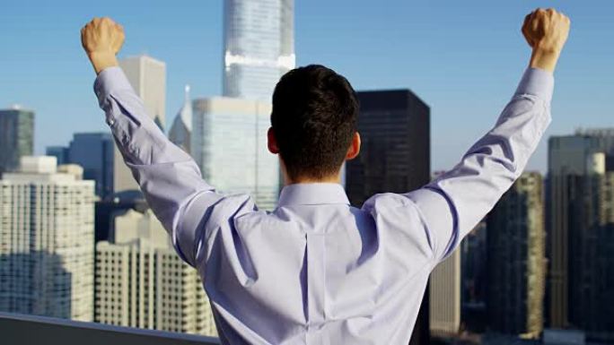亚洲男性庆祝商业成功俯瞰芝加哥城市景观