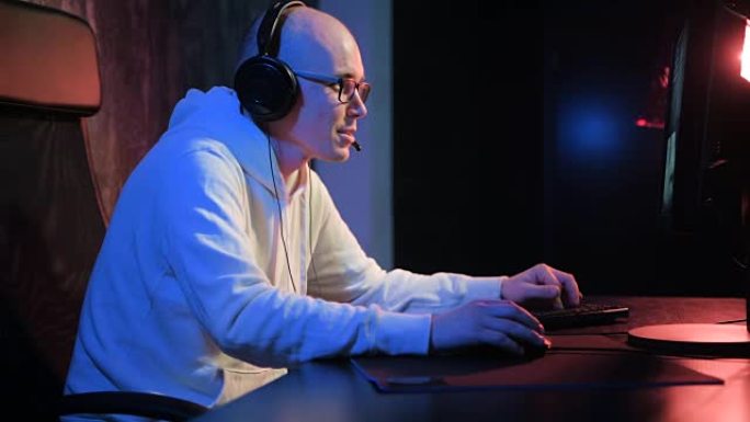 专业玩家在PC计算机上玩激烈的视频游戏。年轻人玩在线竞技游戏并与朋友交谈
