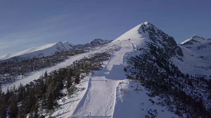 斯洛伐克高塔特拉山脉Strbske Pleso度假村滑雪场上滑雪者的鸟瞰图。原始的未触摸日志格式。