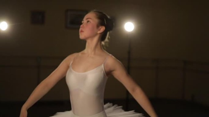 优美的芭蕾舞演员在黑暗中跳舞芭蕾舞元素，背景为光线，缓慢的运动