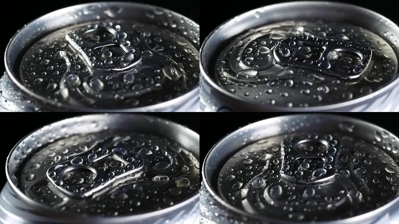 冷饮在黑色背景下旋转。苏打水或啤酒铝罐上的水滴