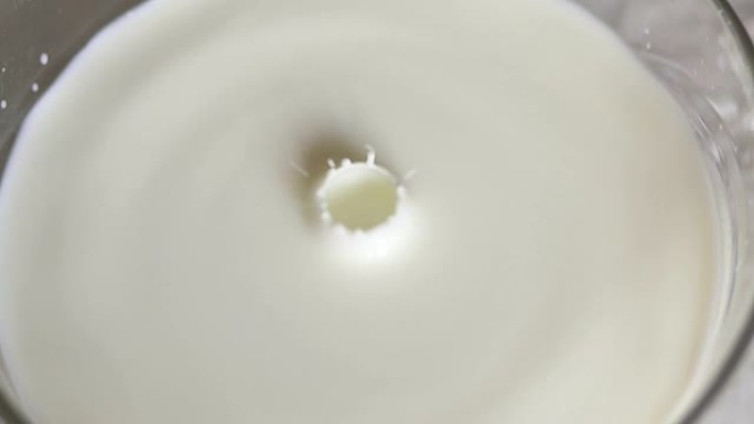 一滴牛奶在一碗牛奶中慢慢落下。