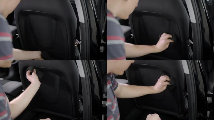 一名男子用海绵清洁和擦拭汽车座椅的特写镜头