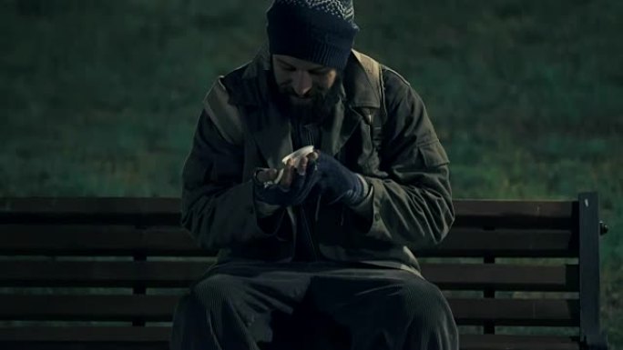 晚上公园里孤独无家可归，数着他的钱买点东西吃