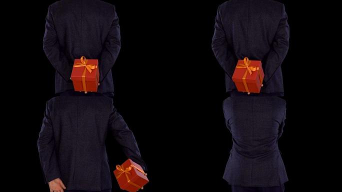 一个穿着西装的男人背着一个红色的礼品盒。高加索人从脚转移到脚。商人送了一份礼物。特写锁定镜头。阿尔法