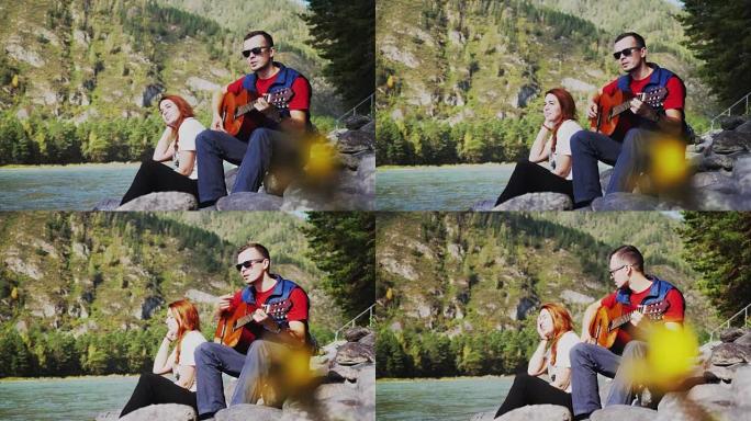 一对夫妇在海边的夏天在山河旁边弹吉他。3840x2160