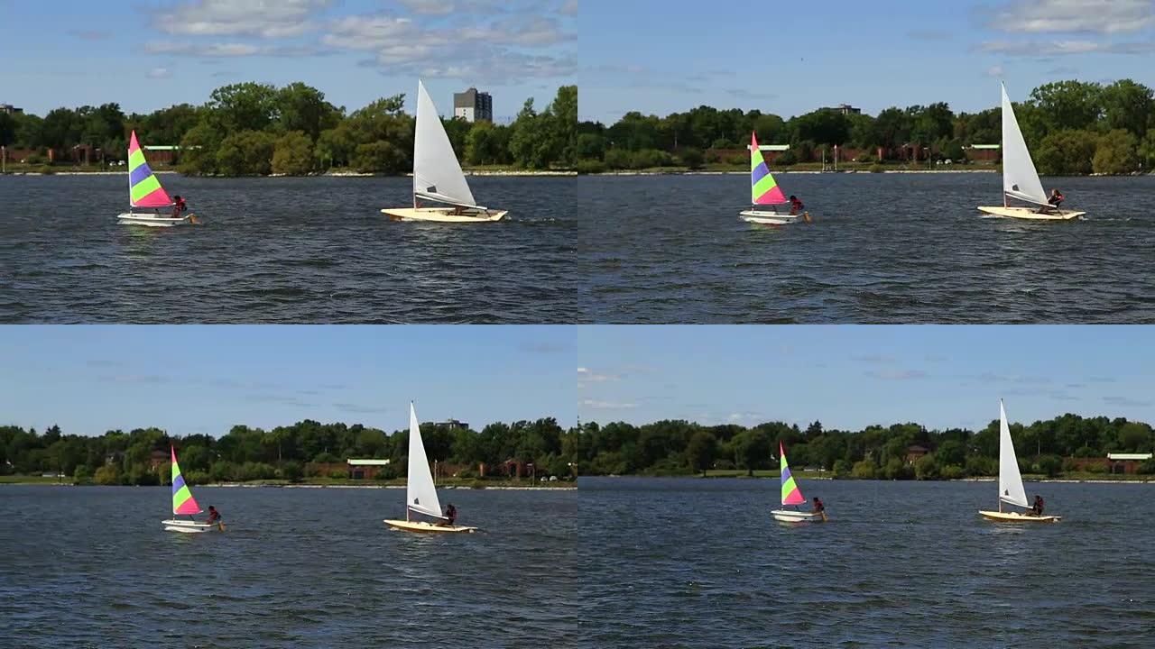 当帆船学校的学生进行演习时，两艘小船在开阔的水面上来回穿梭。