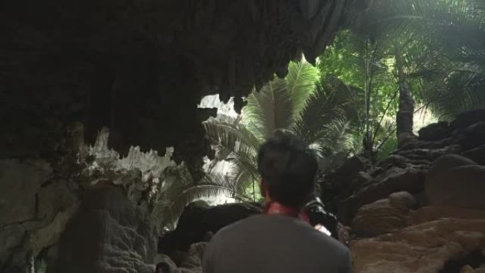 年轻旅行者的背部在泰国Uthaithani的古代森林的洞穴中