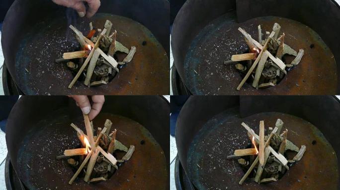 用手烧制炉子中的木材起动器将原木燃烧成木炭