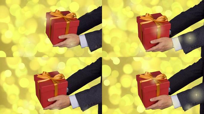 两只男性手握着带有金蝴蝶结的红色礼盒。庆祝前夕礼物盒。穿着古典西装的高加索人。金色灯光背景。锁定。