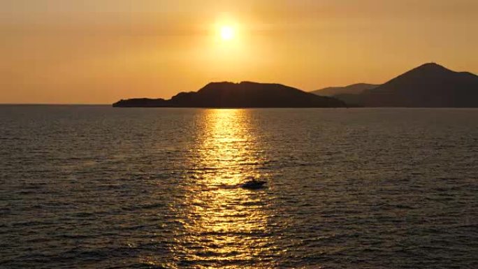 小摩托艇在海上航行在阳光路上的金色日落