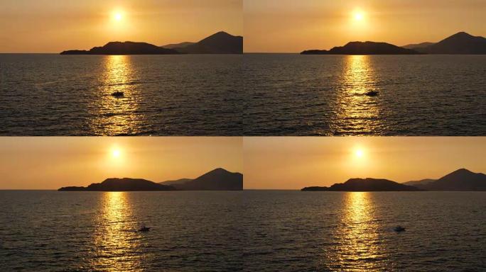 小摩托艇在海上航行在阳光路上的金色日落
