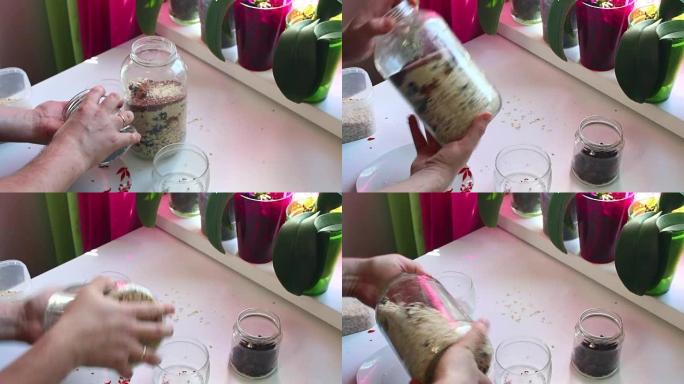 该男子将干果加入带有蔬菜的玻璃罐中，并将其混合。