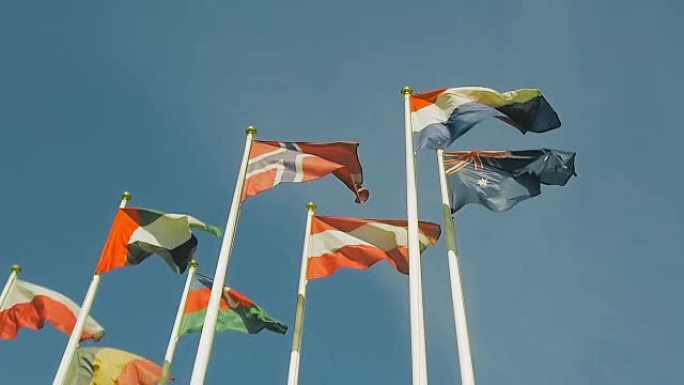 许多不同国家的旗帜，旗帜随风飘动。慢动作