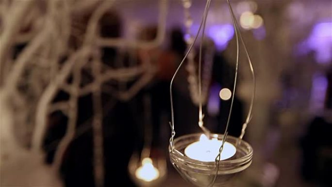 宴会桌上的玻璃烛台，装饰烛台，浅景深，餐厅里跳舞的人的轮廓模糊，餐厅内部，新年，圣诞节，婚礼