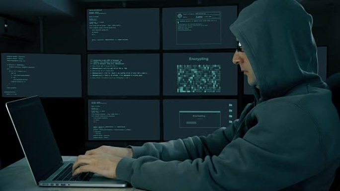 黑客在笔记本电脑上打字。黑夜里，人在电脑上编码。戴墨镜的男人在键盘上打字。侧面形象。监控的房间。