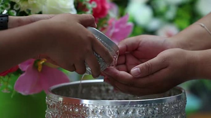 泰国泼水节概念:泰国人庆祝新年泼水节时，会送花环给长辈，并祈求祝福