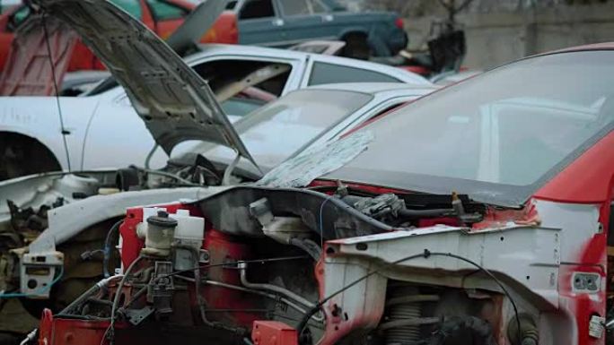 近距离拍摄残破和撕裂的汽车躺在垃圾场上进行回收