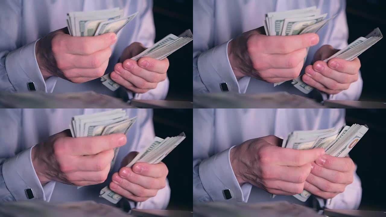 钞票计数特写照片。高加索人数着他辛苦挣来的钱。一百美元的钞票。