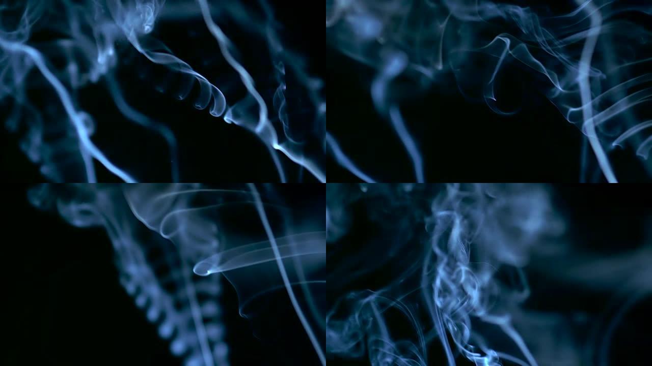 慢动作中蓝色烟雾在黑色背景上升起的特写视频