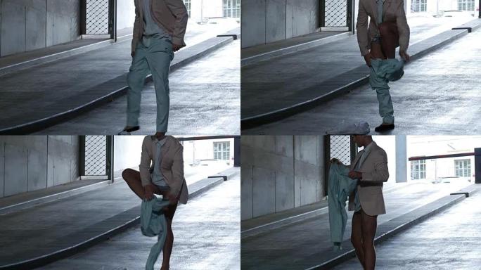男舞者在停车场的坡道上脱衣服