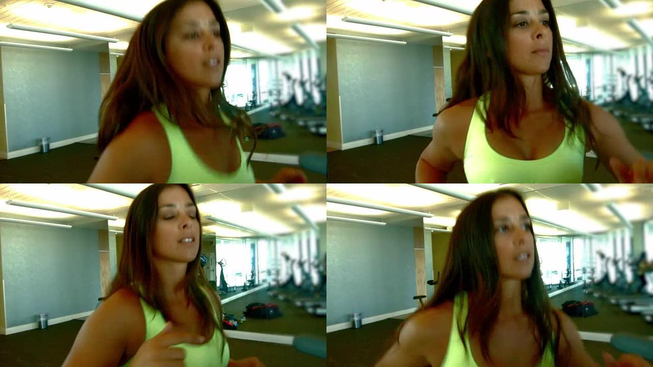 年轻的拉丁裔黑发女子在健身房的跑步机上跑步