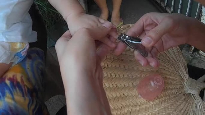母亲用指甲刀修剪女婴的指甲