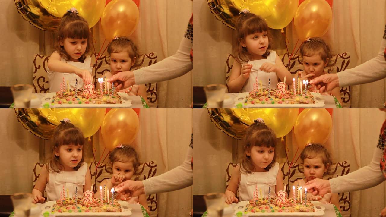 可爱的小女孩和派对上的生日甜点。有趣快乐的孩子。儿童假期的概念。3年。点燃蛋糕上的蜡烛