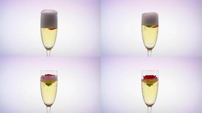 一杯香槟和一个玫瑰花蕾。白色背景。特写