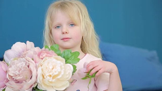 小女孩拿着一个带花的大花瓶，在床上的房间里玩耍