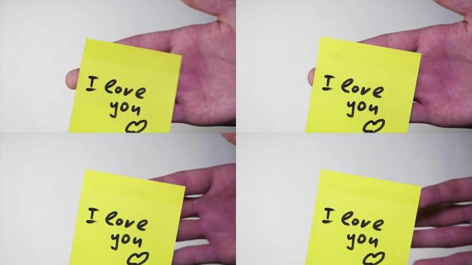 注意我爱你。空白的黄色便笺，上面写着 “我爱你” 在软木公告板上的标志。贴纸上的铭文我爱你在白色背景