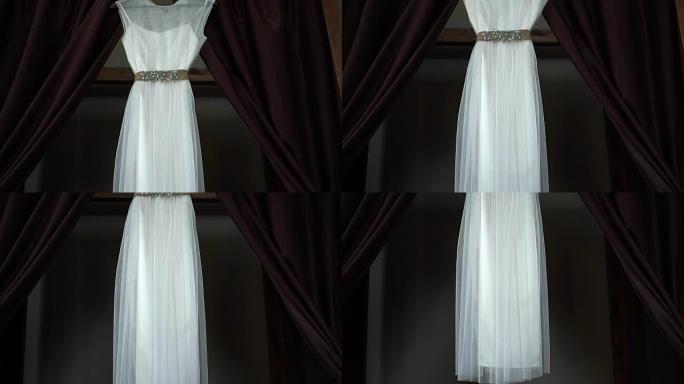 新娘房间里挂着棕色窗帘的衣架的完美婚纱