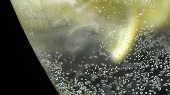 Glass of water with ice and lemon in rotation