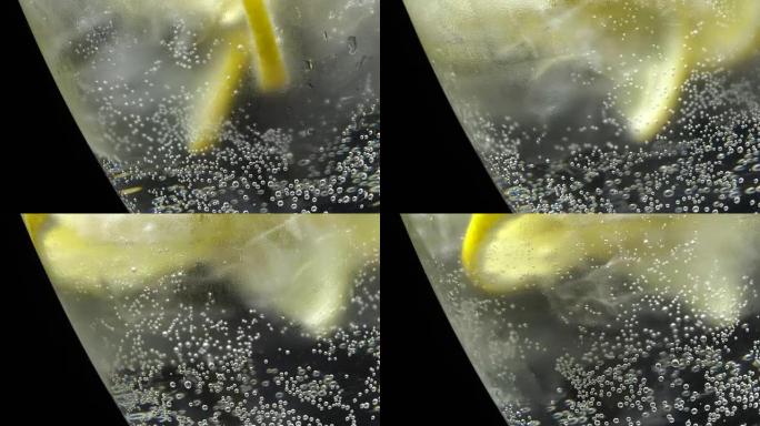 Glass of water with ice and lemon in rotation