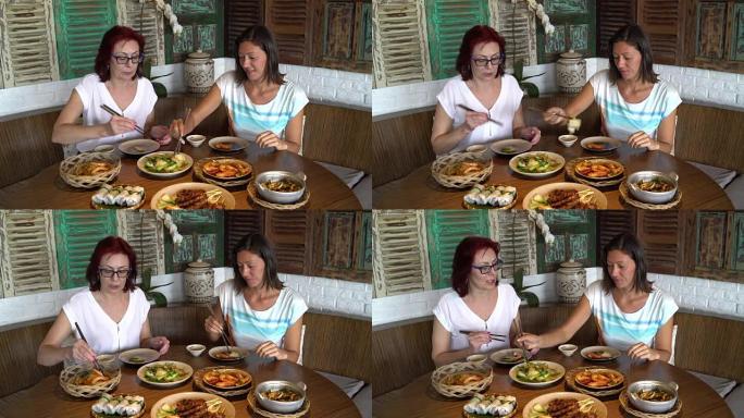女人坐在桌子旁摆着不同的菜，用筷子把自己放在一碗食物中