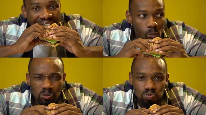表情滑稽的非洲裔美国人在咖啡馆吃汉堡特写
