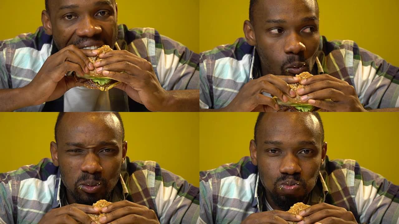 表情滑稽的非洲裔美国人在咖啡馆吃汉堡特写