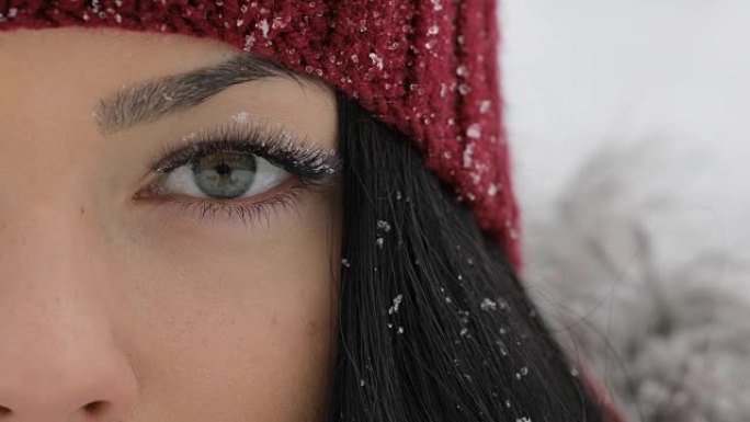 Close-up of woman open her eyes with snow on big e