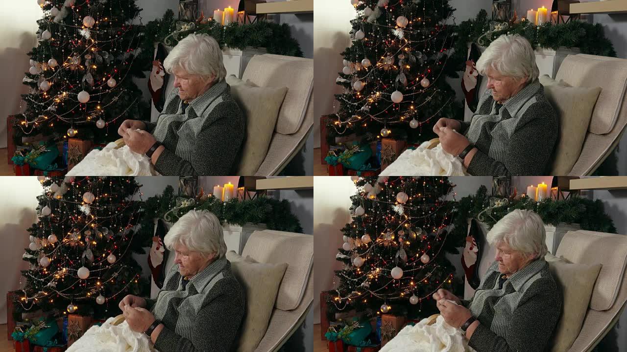 老年妇女在椅子上编织毯子