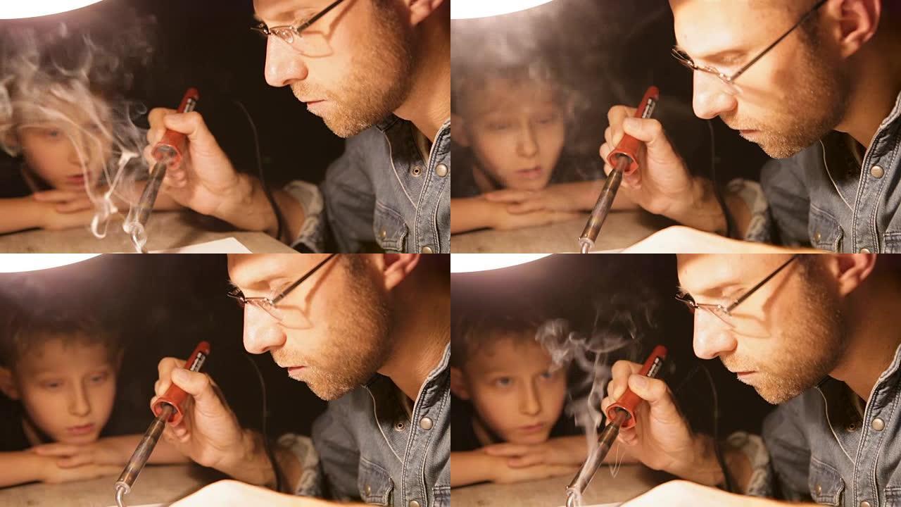 父亲在台灯下焊接电子零件，并与他的小儿子说话