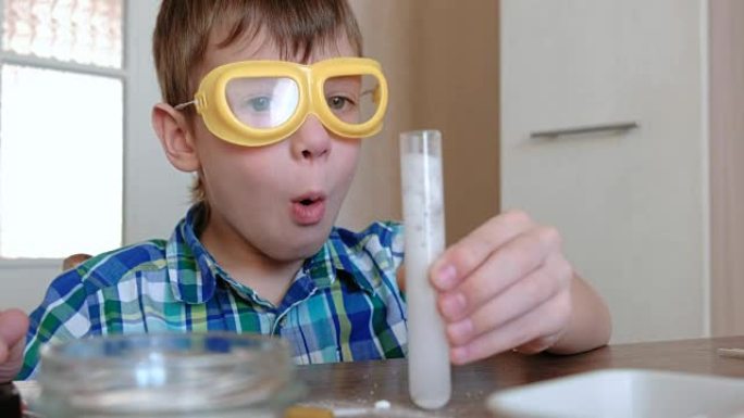 在家进行化学实验。惊讶的男孩的脸看着化学反应与释放的气体在他的试管在他的手。