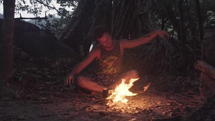 白种人野蛮人在黄昏时分在热带森林里燃烧小篝火，用米饭煮沸晚餐。仪式萨满教围着火跳舞。